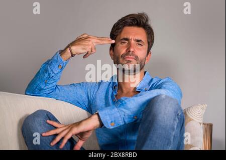 Lifestyle-Porträt von jungen attraktiv und gut aussehend traurig Latin Mann sitzen müde und deprimiert zu Hause Sofa Couch Gefühl überwältigt und besorgt suffe Stockfoto