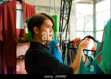 Junge attraktive und coole asiatische Mann Kleidung Store Besitzer oder Mitarbeiter arbeiten bei Beauty-Mode-Shop Organisation Kleidung in Business-Erfolg und Job con Stockfoto