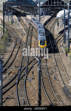 Erhöhte Ansicht des Zuges, der vom Newcastle Central Station nach Norden abfährt; Muster von Gleisen und elektrischen Kabeln über dem Kopf im Vordergrund. Stockfoto