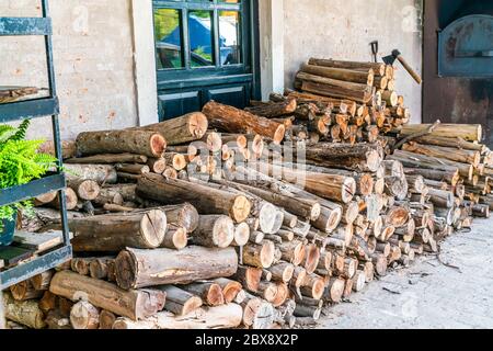 Holzstapel vor einer Wand mit einer klassischen Tür in Uruguay Stockfoto