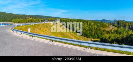 Josefuv Dul-Staudamm, Erdstaudamm im Isergebirge mit Asphaltstraße auf der Spitze, Tschechische Republik. Sonniger Sommertag. Stockfoto