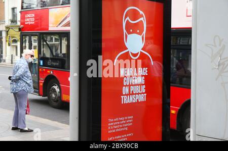 London, Großbritannien. 6. Juni 2020 Transport für London & Mayor of London Hinweis auf eine Bushaltestelle am Bahnhof Richmond, West London. Diese Anleitung zur Gesichtsbedeckung wird am 15. Juni 2020 obligatorisch. Eine maskierte Dame wartet auf einen Bus. Andrew Fosker / Alamy Live News Stockfoto
