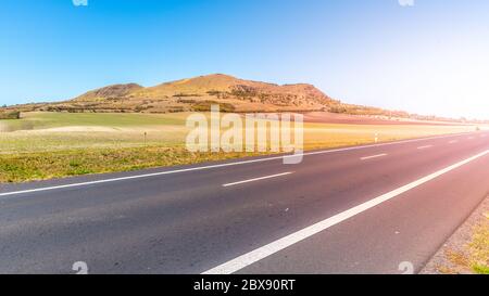 Rana Berg und Asphaltstraße in der Nähe Louny in Mittelböhmischen Hochland an sonnigen Sommertag, Tschechische Republik. Stockfoto