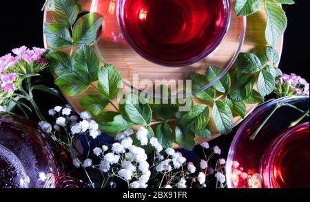 Roter heißer Hibiskus-Tee in einem Glas-Becher. Teestunde: tasse Tee, Karkade, Karkade, Rooibos. Orientalisch, gemütlich, Zeremonie, Tradition, japanisch, belaubt, hygge, autum Stockfoto