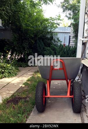 Neuer Metallgarten Trolley in einem botanischen Garten. Gartenarbeiten, im Teil des Blumengartens Stockfoto