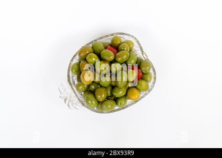 Marinierte Oliven in kleiner transparenter Schüssel. Auf weißem Hintergrund. Eingelegte grüne Oliven Stockfoto