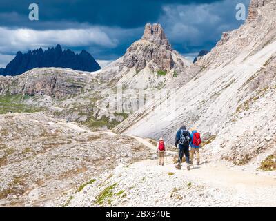 Bergwanderer mit Wanderstöcken wandern auf dem felsigen Weg in den Bergen. Nordic Walking-Thema. Stockfoto