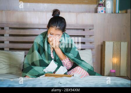 Junge schöne und süße asiatische koreanische Mädchen in Pyjamas krank zu Hause Schlafzimmer leiden Kälte und Grippe unter Temperatur mit Thermometer im Bett weht Stockfoto