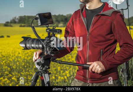 Kameramann mit professioneller DSLR-Kamera für digitale Aufnahmen auf einem Stativ. Stockfoto