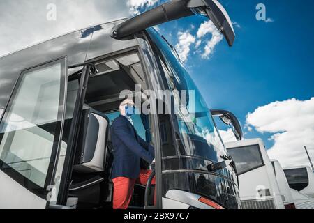 Charter Motor Bus Fahrer Trägt Virus Ausbruch Maske Wartet Urlaub Ziel Passagiere. Fernverkehr Während Pandämie. Stockfoto