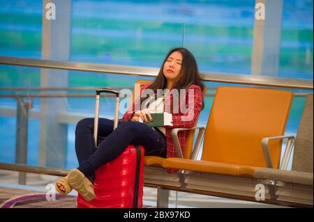 Lifestyle-Porträt von jungen ziemlich müde und erschöpft asiatischen koreanischen touristischen Frau im Flughafen schlafen gelangweilt sitzen am Boarding Gate Halle warten auf Stockfoto