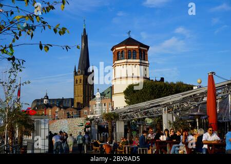 Die beliebte Touristenattraktion Rheinpromenade mit den beiden Wahrzeichen Schlosssturm und Lambertuskirche im Hintergrund. Stockfoto