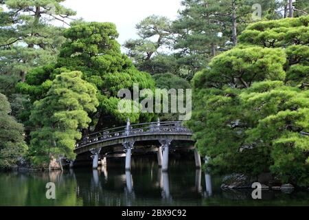Bewundern Sie Ihre Reflexion von der kunstvollen Brücke im Oikenawa Garten, wie es die Kaiser und Kaiserin früher waren. Stockfoto