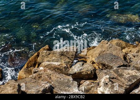 Nahaufnahme eines Wellenbrechers aus riesigen Felsbrocken, Mittelmeer, in Ligurien, Italien, Europa Stockfoto