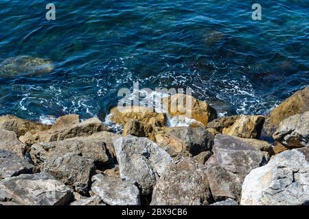 Nahaufnahme eines Wellenbrechers aus riesigen Felsbrocken, Mittelmeer, in Ligurien, Italien, Europa Stockfoto