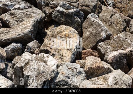 Nahaufnahme eines Wellenbrechers aus riesigen Felsbrocken am Meer, Vollbild. Ligurien, Italien, Europa Stockfoto