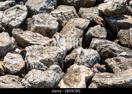 Nahaufnahme eines Wellenbrechers aus riesigen Felsbrocken am Meer, Vollbild. Ligurien, Italien, Europa Stockfoto