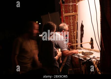 Hacivat und Karagoz aus dem traditionellen osmanischen türkischen Schattentheater. Beliebtes Puppentheater. Puppenspieler hält die Puppe dicht an der Leinwand. Stockfoto