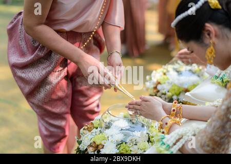 Heilige Wasser Gießen Zeremonie über Braut und Bräutigam Hände, Thai traditionelle Hochzeit Engagement Stockfoto