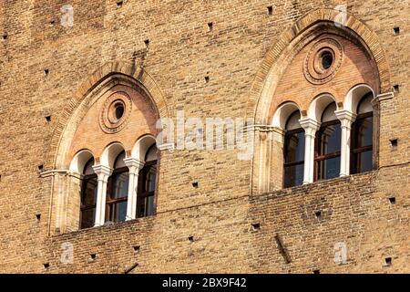 Zwei Doppelfenster (dreifach - Dreifachlanze) des mittelalterlichen Palazzo Re Enzo (König Enzo Palast, 1245) auf der Piazza del Nettuno, Bologna. Italien. Stockfoto