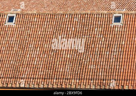 Pantile. Nahaufnahme eines alten Hausdaches mit Fliesen aus Lehm (Coppo in italienischer Sprache), und Oberlichter, von oben gesehen in Bologna Stadt, Italien. Stockfoto