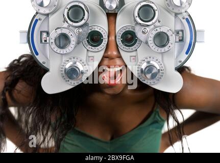 Junge und glückliche schwarze afro amerikanische Frau im Krankenhaus Blick durch optometrische Krankenhaus Gerät Überprüfung Augen mit Sehuntersuchung in der Augenheilkunde heilen Stockfoto