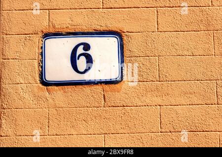 Altes Haus Nummer sechs auf der orangefarbenen Wand, Bologna Innenstadt, Emilia-Romagna, Italien, Europa Stockfoto