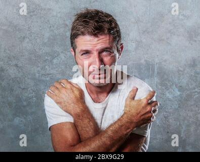 Portrait von traurig und deprimiert Mann umarmt und umarmt sich verzweifelt Gefühl frustriert und hilflos in Depression und Traurigkeit Gesichtsausdruck Stockfoto