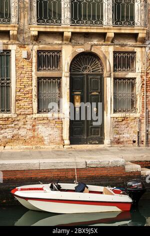 Nahaufnahme eines alten Hauses mit einem kleinen Motorboot, das im Kanal der Lagune von Venedig festgemacht ist. UNESCO-Weltkulturerbe, Venetien, Italien, Europa Stockfoto