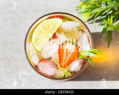 Erfrischender Sommercocktail Limonade mit Eis, Limette, Erdbeeren und Estragon Stockfoto