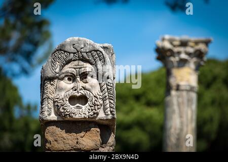 Steintheatermaske aus der Dekoration des Amphitheaters in Ostia Antica, römische Kolonie gegründet im 7. Jahrhundert v. Chr.. Rom, UNESCO-Weltkulturerbe si Stockfoto