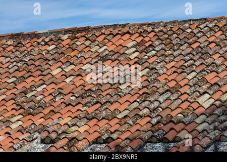 Pantile. Nahaufnahme eines Daches mit neuen und alten Terrakotta-Fliesen (Coppo in italienischer Sprache), auf einem blauen Himmel mit Wolken. Venetien, Italien, Europa Stockfoto