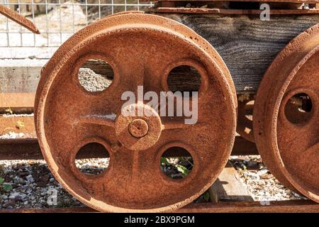 Nahaufnahme von rostigen Rädern eines alten Bergwerkwagens auf den Schienen. Friaul Julisch Venetien, Italien, Europa Stockfoto