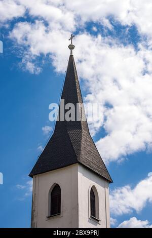 Glockenturm einer kleinen Kirche in Österreich, im kleinen Dorf Oberschutt, Villach, Kärnten, Österreich, Europa. Kirche der Heiligen Maria Magdalena Stockfoto