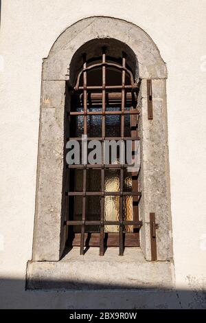 Altes Fenster mit schmiedeeisernen Sicherheitsstangen. Altes Heiligtum des Monte Santo di Lussari. Friaul Julisch Venetien, Italien, Europa Stockfoto