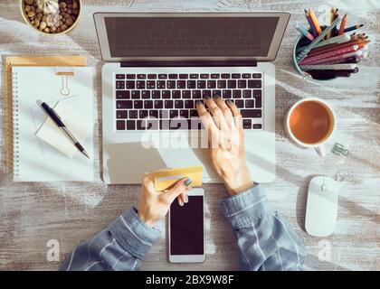 Online-Shopping-Konzept. Unkenntlich Frau, die Tee trinkt und Laptop anschaut Stockfoto