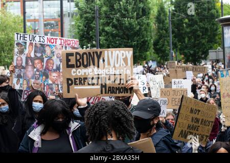 Schwarze Leben Materie Protest Manchester UK. Protestierende verlassen Piccadilly Gardens in Richtung Market Street. Frau hält Schildertext Ebony und Ivory hoch Stockfoto