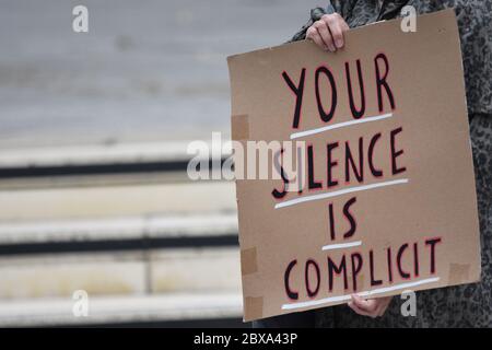 Ein Banner mit der Aufschrift „Ihr Schweigen ist Mitschuld“ auf einer britischen Protestdemonstration von Black Lives Matter im Vereinigten Königreich im Jahr 2020 Stockfoto