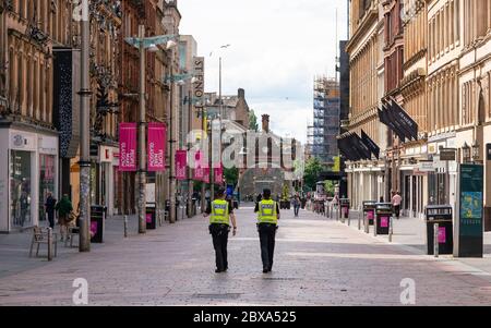 Glasgow, Schottland, Großbritannien. Juni 2020. Normalerweise geschäftiges Einkaufsviertel der Buchanan Street im Stadtzentrum von Glasgow ist an einem Samstagmittag fast menschenleer. Geschäfte und Geschäfte bleiben geschlossen und in vielen Fällen verladen. Polizei Patrouille leere Buchanan Street Fußgängerzone. Iain Masterton/Alamy Live News Stockfoto