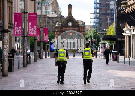 Glasgow, Schottland, Großbritannien. Juni 2020. Normalerweise geschäftiges Einkaufsviertel der Buchanan Street im Stadtzentrum von Glasgow ist an einem Samstagmittag fast menschenleer. Geschäfte und Geschäfte bleiben geschlossen und in vielen Fällen verladen. Polizei Patrouille leere Buchanan Street Fußgängerzone. Iain Masterton/Alamy Live News Stockfoto