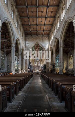 Das Innere der St. Botolph's Church in Boston, Lincolnshire blickt entlang des zentralen Seitenschiffs auf den hohen Altar mit Sonnenlicht, das durch die Fenster strömt Stockfoto