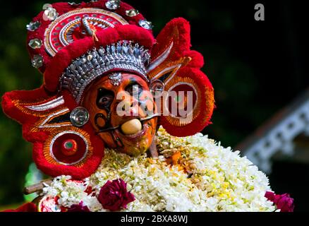 Die rituelle Kunst Form von Kerala, Thyra oder Theyyam thira ist ein ritueller Tanz, der in 'Kaavu'(Hain)& Tempeln des Kerala, Indien, aufgeführt wird Stockfoto