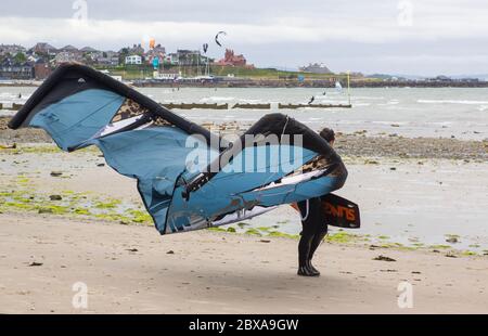 6. Juni 2020 EIN junger Kitesurfer bringt seine Ausrüstung am Ballyholme Beach in Bangor, Nortgern Irland, an den Rand des Wassers, während er sich auf ein paar Kiten vorbereitet Stockfoto