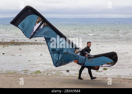 6. Juni 2020 EIN junger Kitesurfer bringt seine Ausrüstung am Ballyholme Beach in Bangor, Nortgern Irland, an den Rand des Wassers, während er sich auf ein paar Kiten vorbereitet Stockfoto