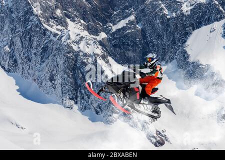 Schneemobil-Sprung in der alpinen Umgebung Stockfoto