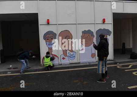 Die Menschen malen ein Wandgemälde, während sie an einer Protestkundgebung in der Black Lives Matter auf dem Custom House Square in Belfast teilnehmen, in Erinnerung an George Floyd, der am 25. Mai in Polizeigewahrsam in der US-Stadt Minneapolis getötet wurde. Stockfoto