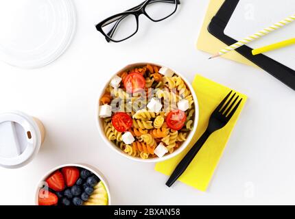 Essen in wegnehmbaren Boxen auf weißem Tisch mit Notizblock Stockfoto