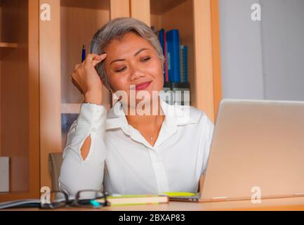 Corporate Job Lifestyle Porträt von glücklich und erfolgreich Attraktive mittleren Alters asiatische Frau arbeiten im Büro Laptop Computer Schreibtisch zufrieden und effic Stockfoto