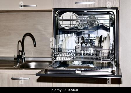 Nassbereich in Küchenmöbeln. Eine Spülmaschine und ein Waschbecken mit gefiltertem und Leitungswasser. Stockfoto