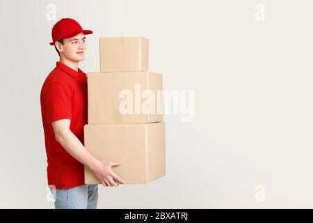 Postbote stellt Pakete aus. Arbeiter hält Stapel von Paketen in seinen Händen Stockfoto
